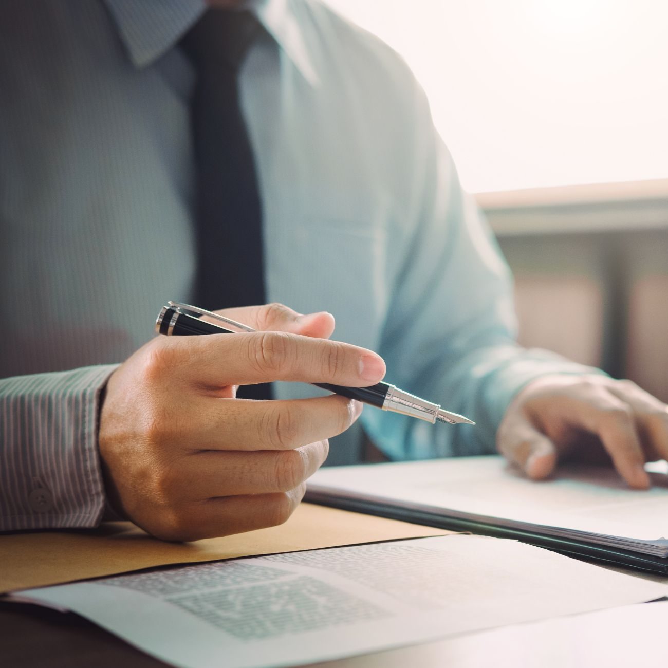 Person holding a pen at a desk