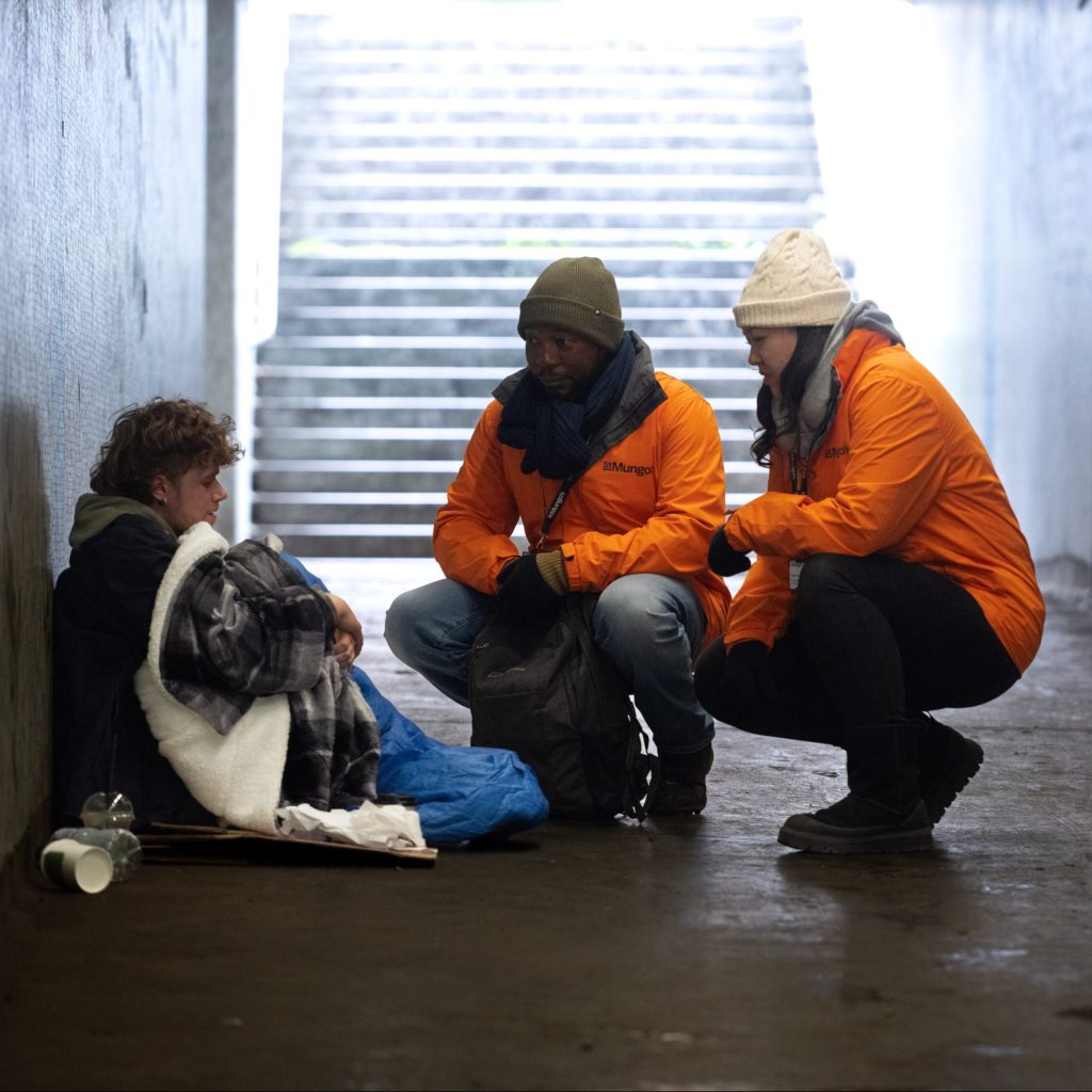 Two St Mungo's staff members speaking to a person rough sleeping