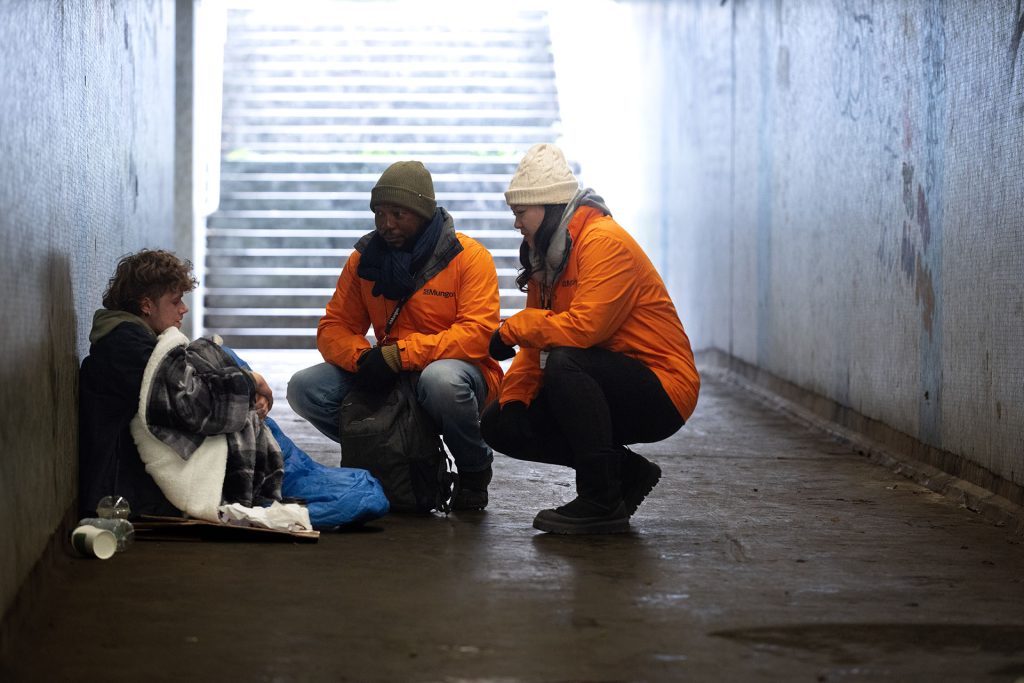 Two St Mungo's staff members speaking to a person rough sleeping