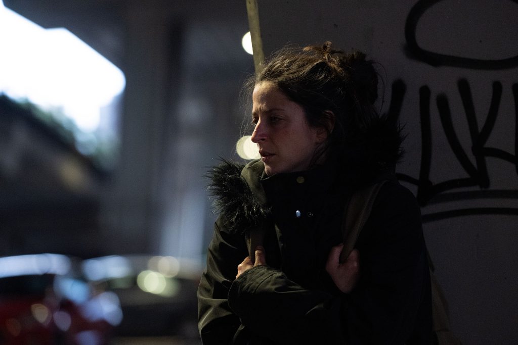 Nighttime portrait of person outdoors in coat