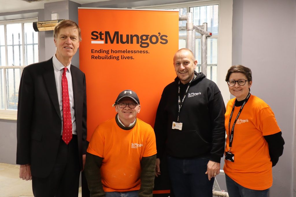 Staff stood with a government minister next to a St Mungo's banner