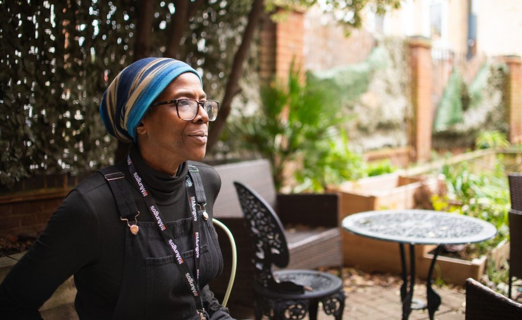 St Mungo's staff member sat in a garden